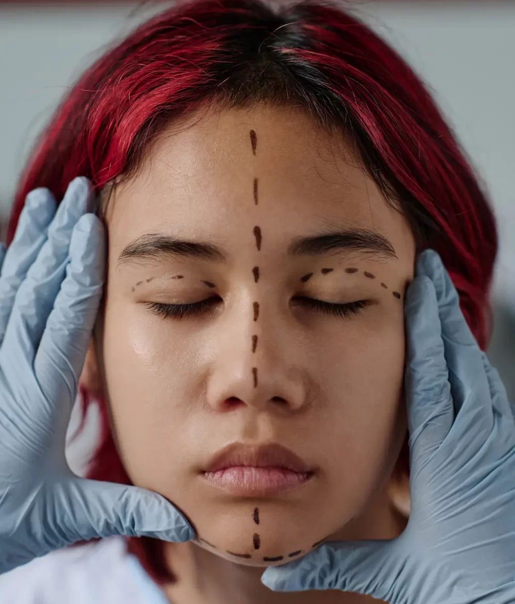 gloved-hands-of-plastic-surgeon-touching-face-of-t-2023-12-14-15-28-03-utc